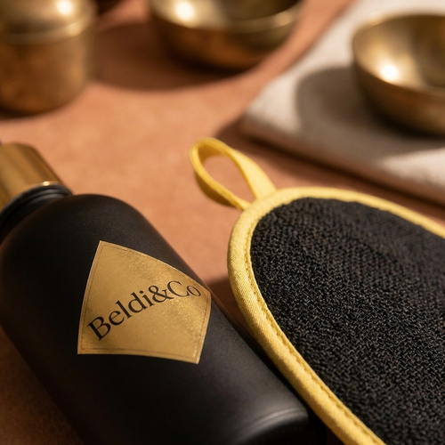 Close-up detail of Argan Oil bottle and Kessa mitt for Glow & Oil Finish Set
